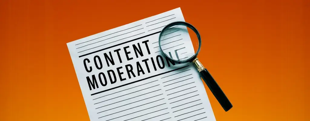 A magnifying glass an a web design in the background with the word “Content Moderation”